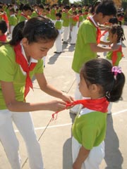 老队员为新队员佩戴红领巾